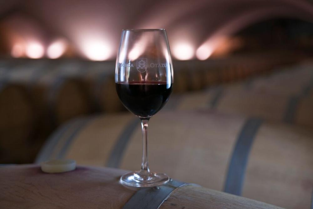 una copa de vino sobre una barrica